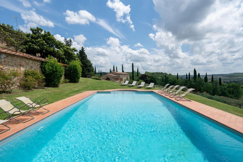 une grande piscine avec des chaises et une maison dans l'établissement I Sodi di Bibbiano, à Lilliano