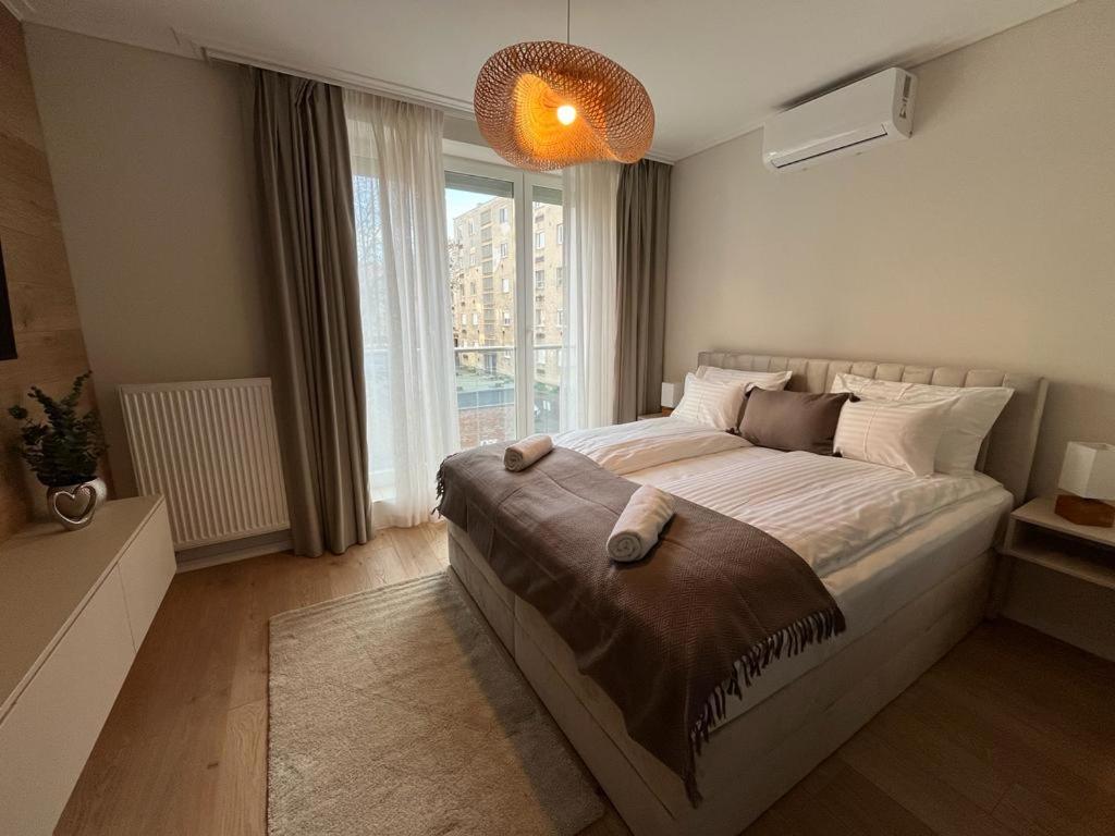 ein Schlafzimmer mit einem großen Bett und einem großen Fenster in der Unterkunft Cityluxandloft Bestern 2 in Szeged
