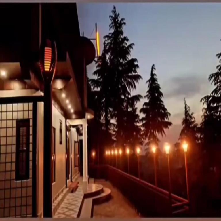 a row of lights on a fence at night at Hotel Full Moon Night in Dalhousie