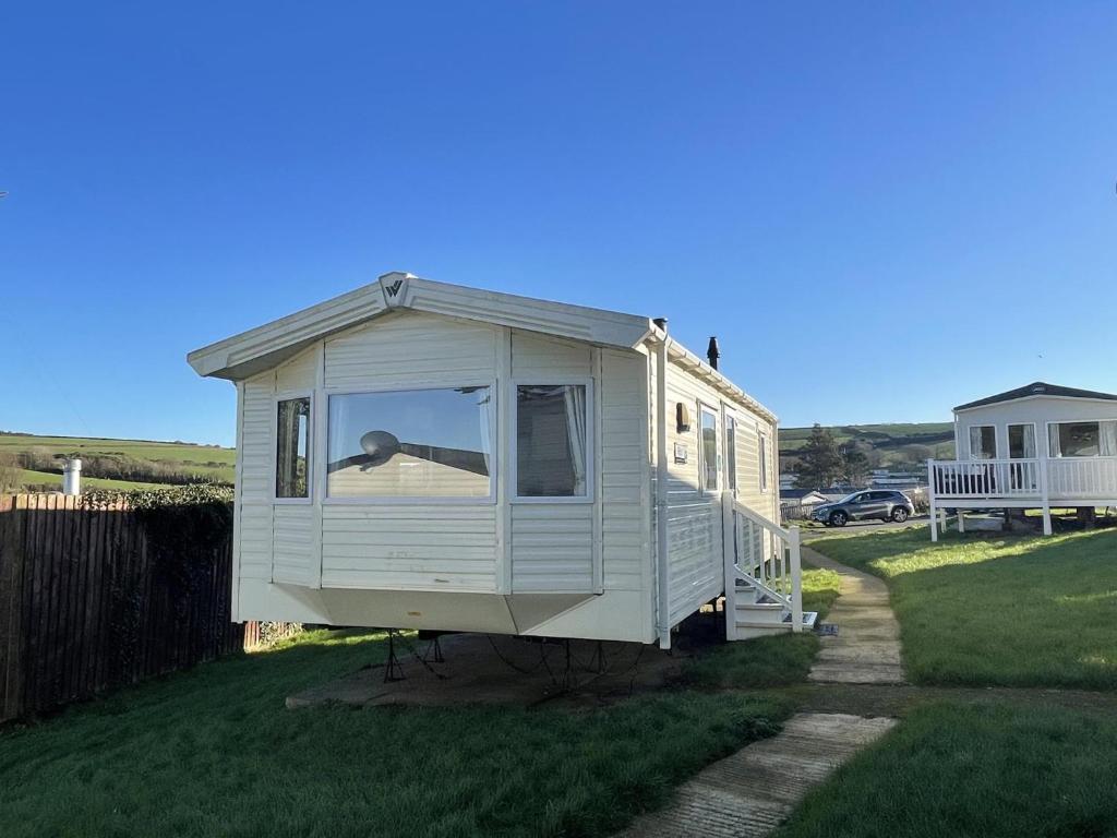 una pequeña casa blanca sentada en el césped en Newquay Bay Resort Sandy Toes - Hosting up to 6 en Newquay