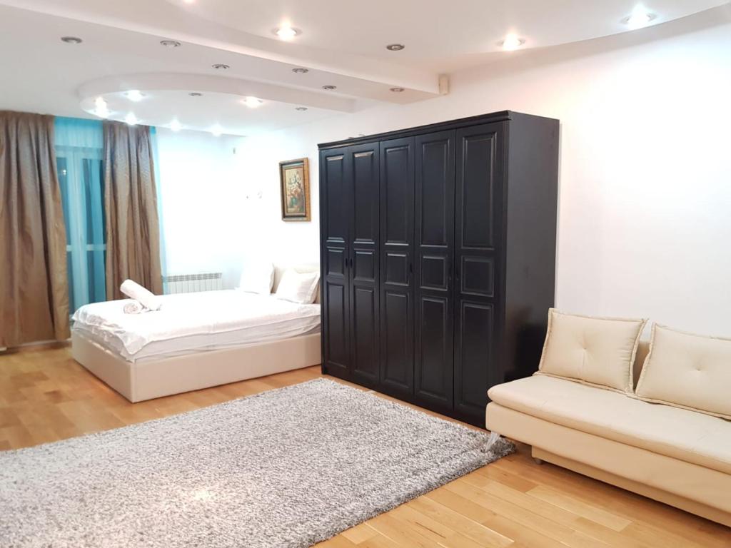a bedroom with a large black cabinet and a couch at Open Space Apartment National Arena Monza in Colonişti