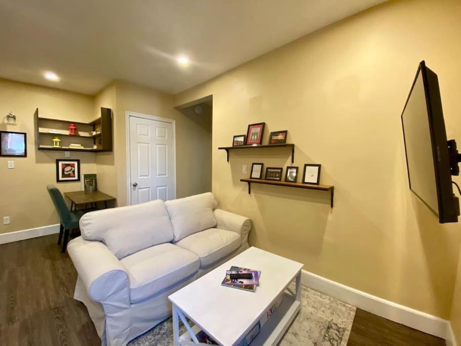 a living room with a white couch and a table at Large Townhouse, Lower Floor with AC, City Center in Halifax