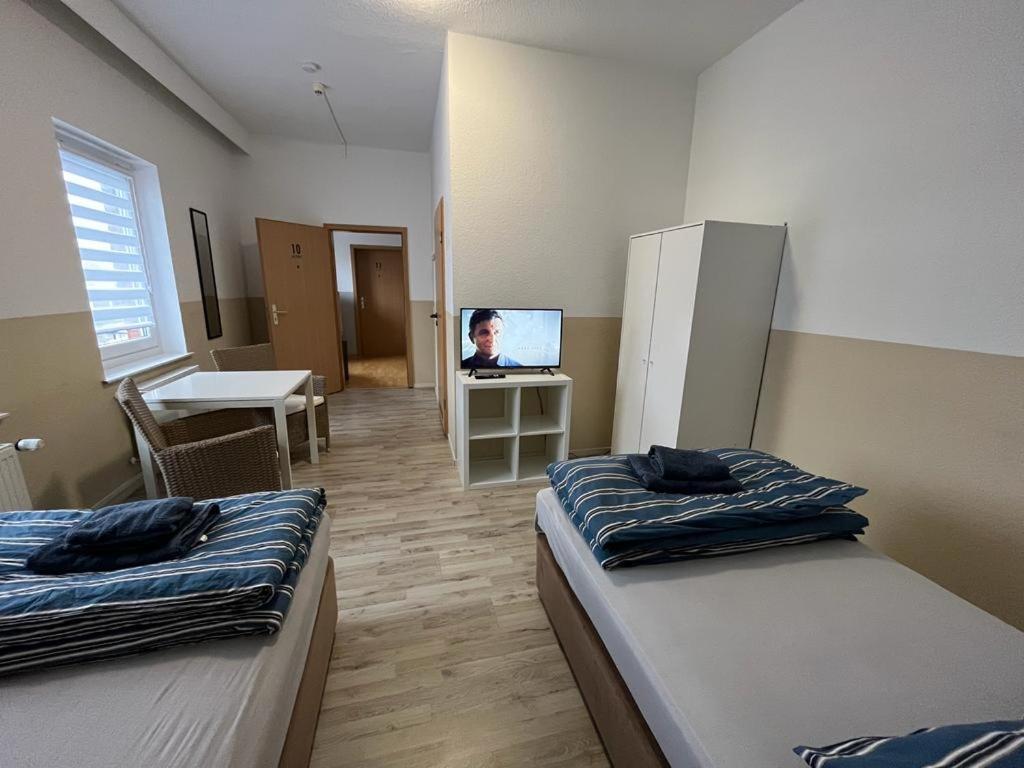 a room with two beds and a tv in it at MWM Gästehaus-Zimmervermietung in Meine