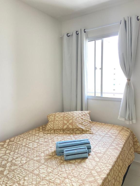 um quarto com uma cama com duas toalhas azuis em Quarto Privado em Aracaju
