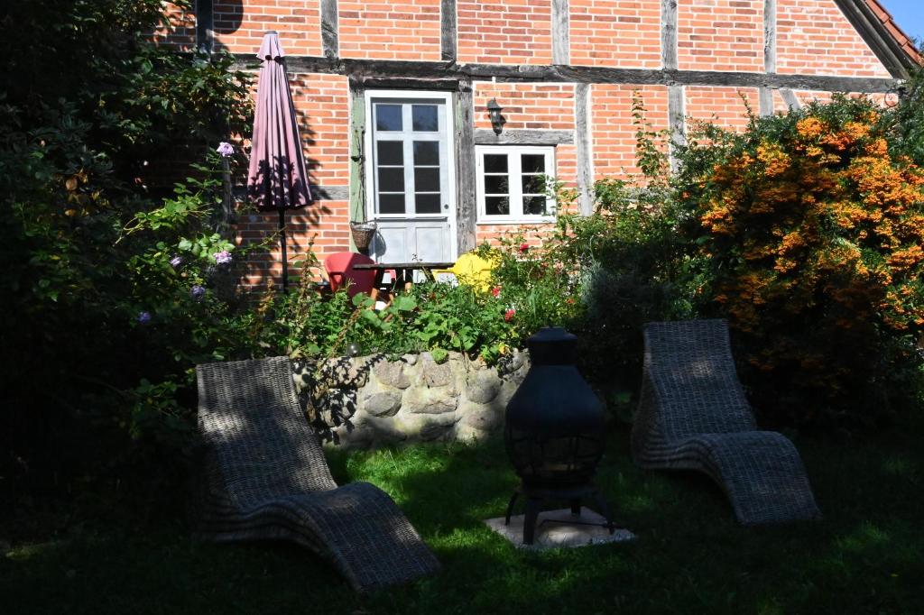 two chairs and a vase in front of a house at Mecklenbü mit Teich, Kamin, Sauna und Hotpott in Dargun