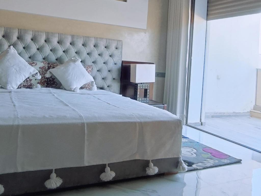 a bedroom with a large bed and a mirror at Tayyurt Surf Camp Tamraght Aourir in Awrir