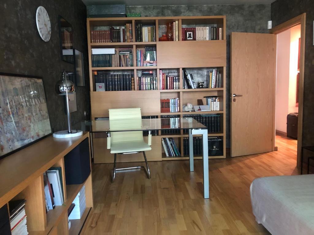 Cette chambre dispose d'un bureau, d'une chaise et d'étagères. dans l'établissement Olga apartment, à Riga