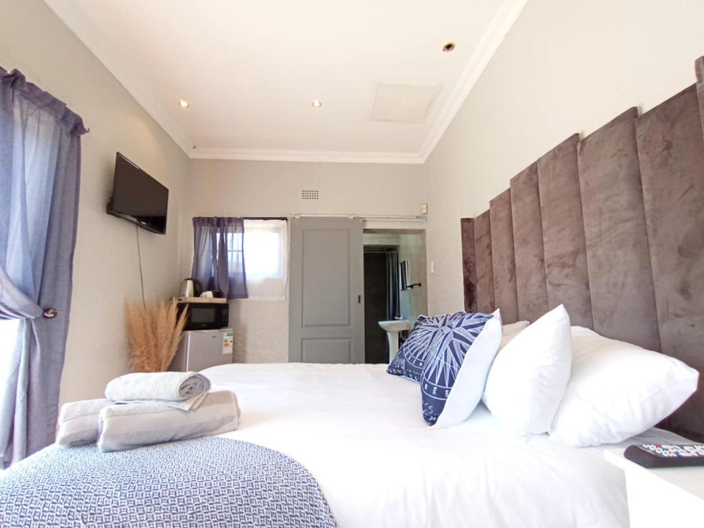 a bedroom with a large white bed with white pillows at OR Tambo Stay Unit 2 in Boksburg