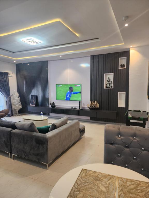 a living room with a couch and a flat screen tv at Wonder court 2 lekki phase1 in Lekki