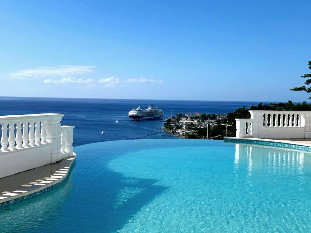 a large swimming pool with a cruise ship in the water at ElDorado Guesthouse in Roseau