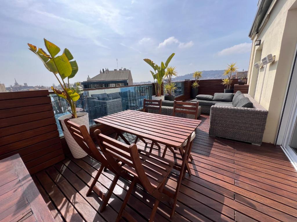 a wooden deck with a table and chairs on a balcony at Magnificent penthouse in Barcelona