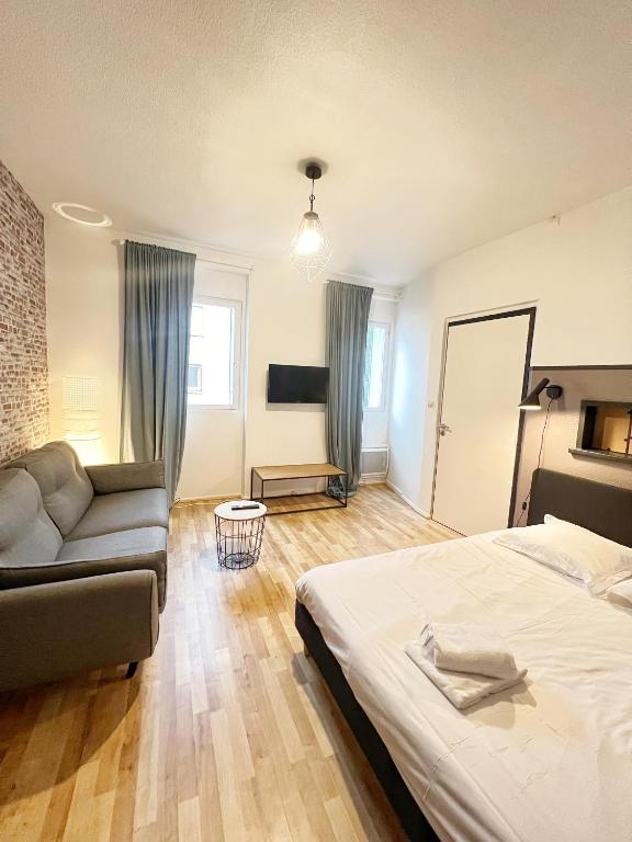 une chambre avec un lit et un canapé dans l'établissement L'industriel de Kléber - Gare - Netflix - Calme, à Toulouse