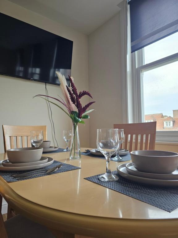 a dining room table with a vase of flowers on it at Town center modern apartment 10 in Ipswich