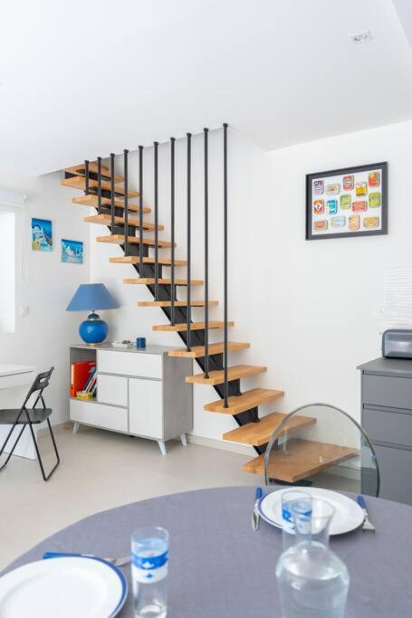 a living room with a spiral staircase with a table at Maison avec jardin &quot;les Néréïdes&quot; port et plage de la Pointe Rouge Marseille in Marseille