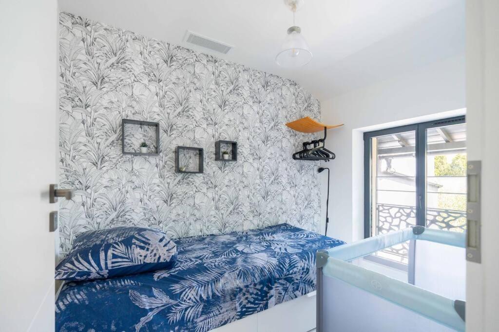 a bedroom with a bed and a wall with wallpaper at Maison avec jardin &quot;les Néréïdes&quot; port et plage de la Pointe Rouge Marseille in Marseille