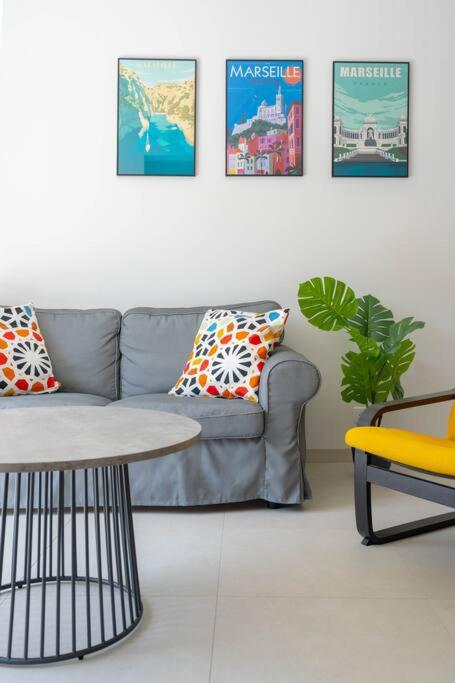 a living room with a couch and a table at Maison avec jardin &quot;les Néréïdes&quot; port et plage de la Pointe Rouge Marseille in Marseille