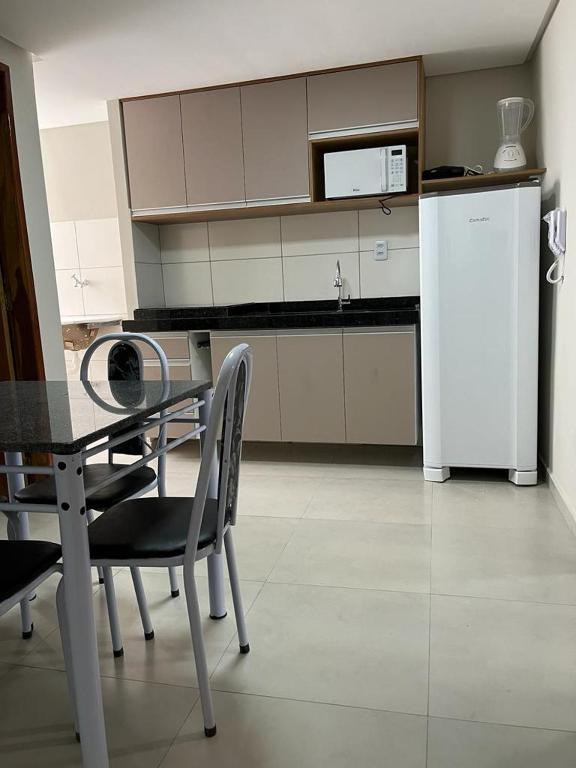 una cucina con tavolo e sedie e frigorifero di Flats Prime a Juazeiro do Norte