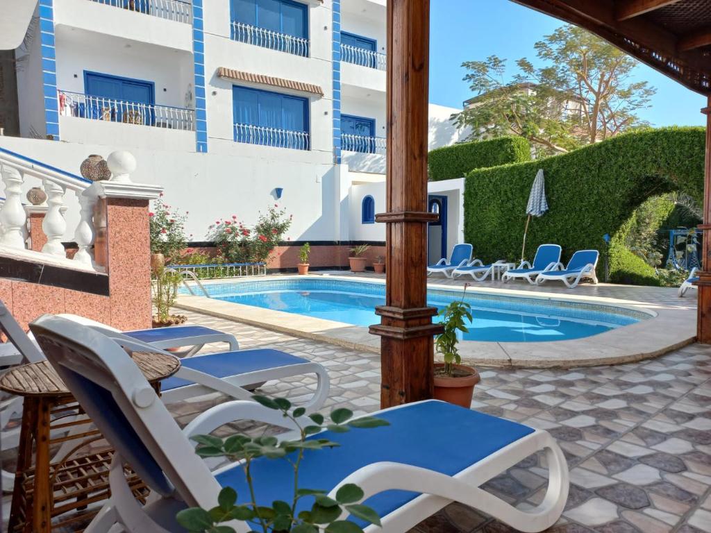 a patio with chairs and a swimming pool at Villa Kaslan Apartments in Luxor