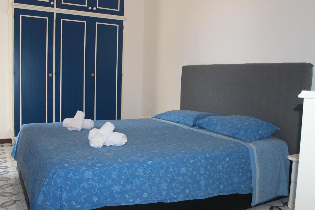 due animali di peluche su un letto con lenzuola blu di Casa dei Pini - Baia Verde a Gallipoli