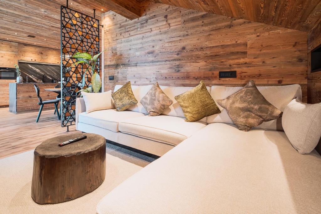 een woonkamer met een witte bank en een houten muur bij Apartments Villa Sofia in Santa Cristina in Val Gardena