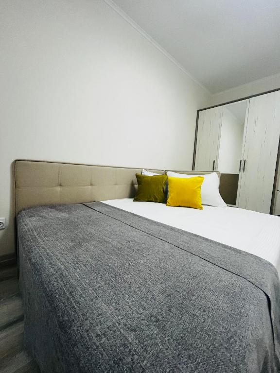 - une chambre avec un grand lit et des oreillers jaunes dans l'établissement Апартаменти поряд дорослої і дитячої лікарні біля Миколайчука, Орлика, à Lviv