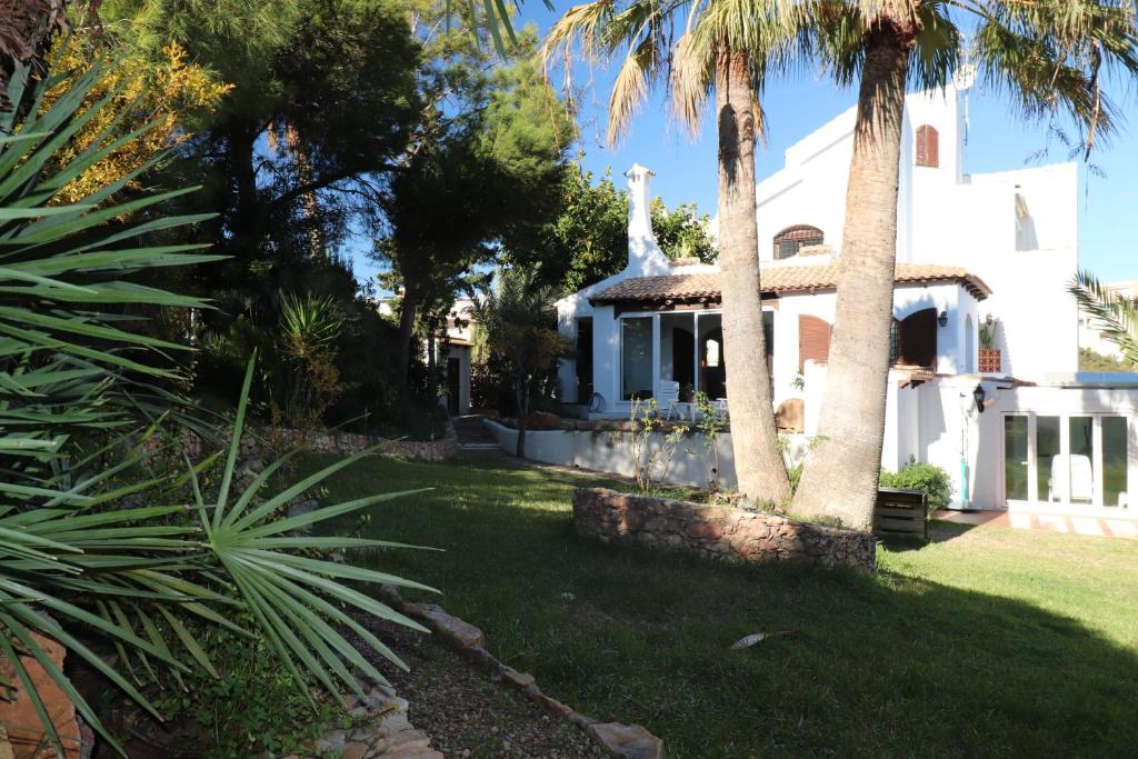 une maison blanche avec des palmiers dans la cour dans l'établissement Castillo Odalbodsol, à Cap de Palos