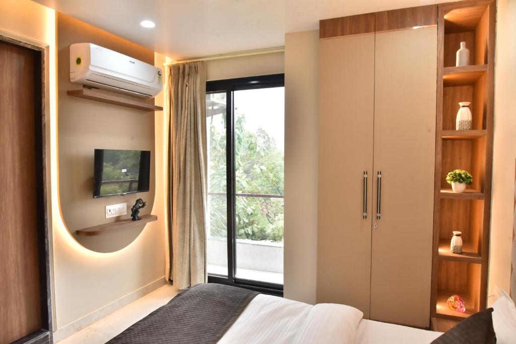 1 dormitorio con 1 cama, TV y ventana en Hotel Shree Krishna, en Jaipur