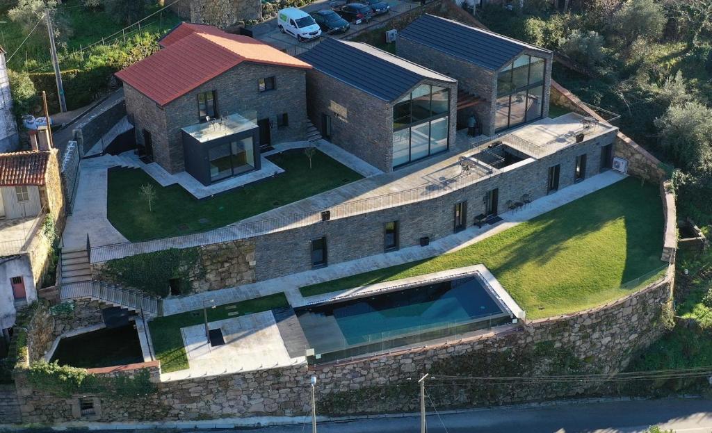 una vista aérea de una casa con una pared de piedra en SERRA en Cortes do Meio