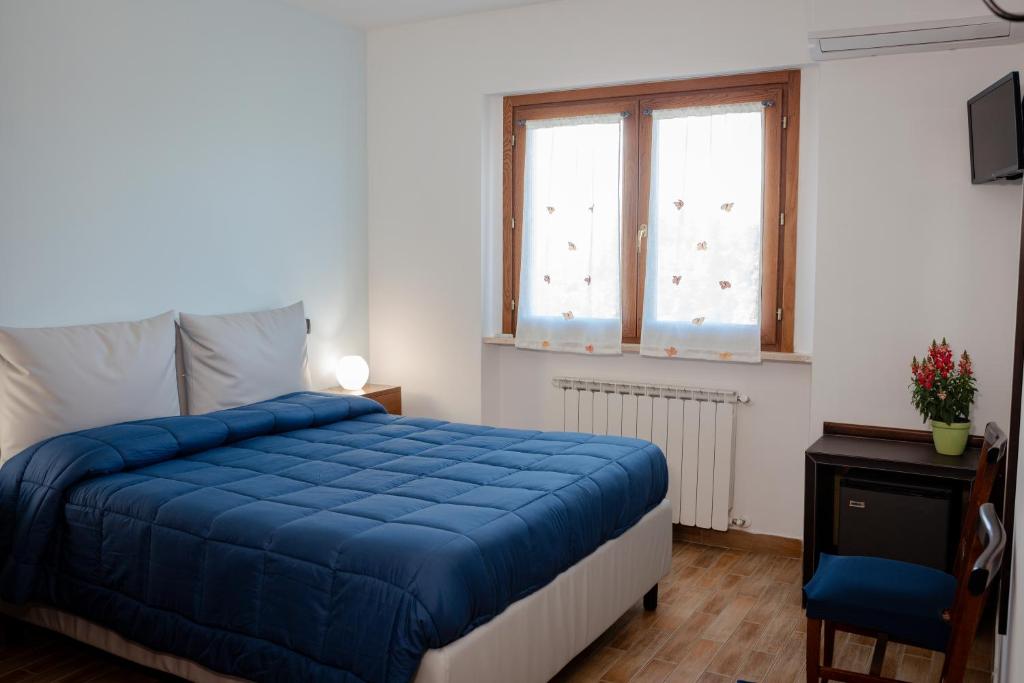 a bedroom with a blue bed and a window at Villa Marianna in Vasto