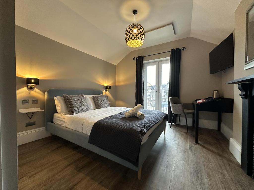 a bedroom with a bed and a table and a window at Number One Hundred Bed And Breakfast in Cardiff