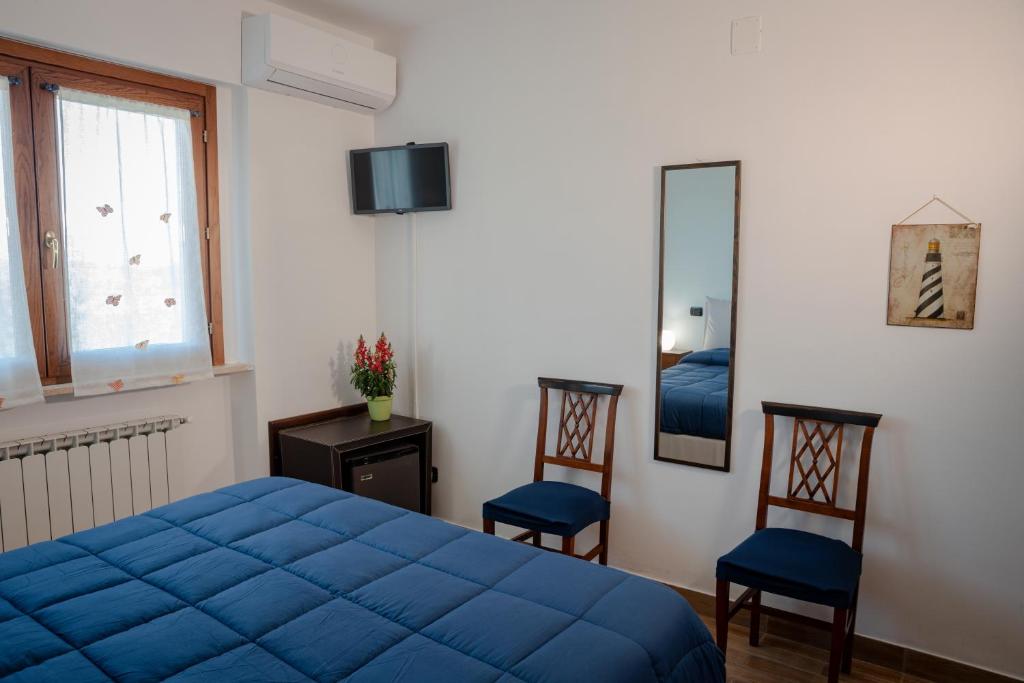 a bedroom with a blue bed and two chairs at Villa Marianna in Vasto