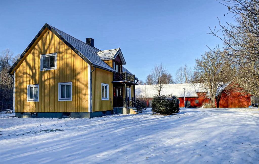 a yellow house with snow on the ground at Awesome Home In Hyltebruk With Wifi in Hyltebruk