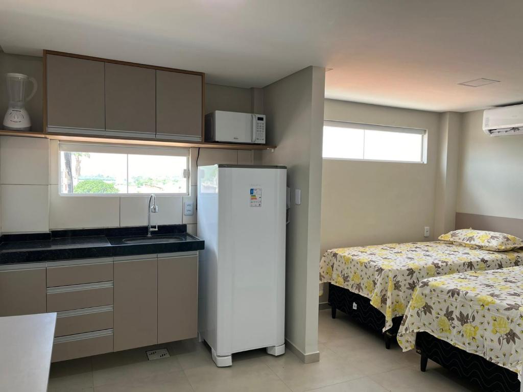 a kitchen with a refrigerator next to a bed at Pousada Prime in Juazeiro do Norte