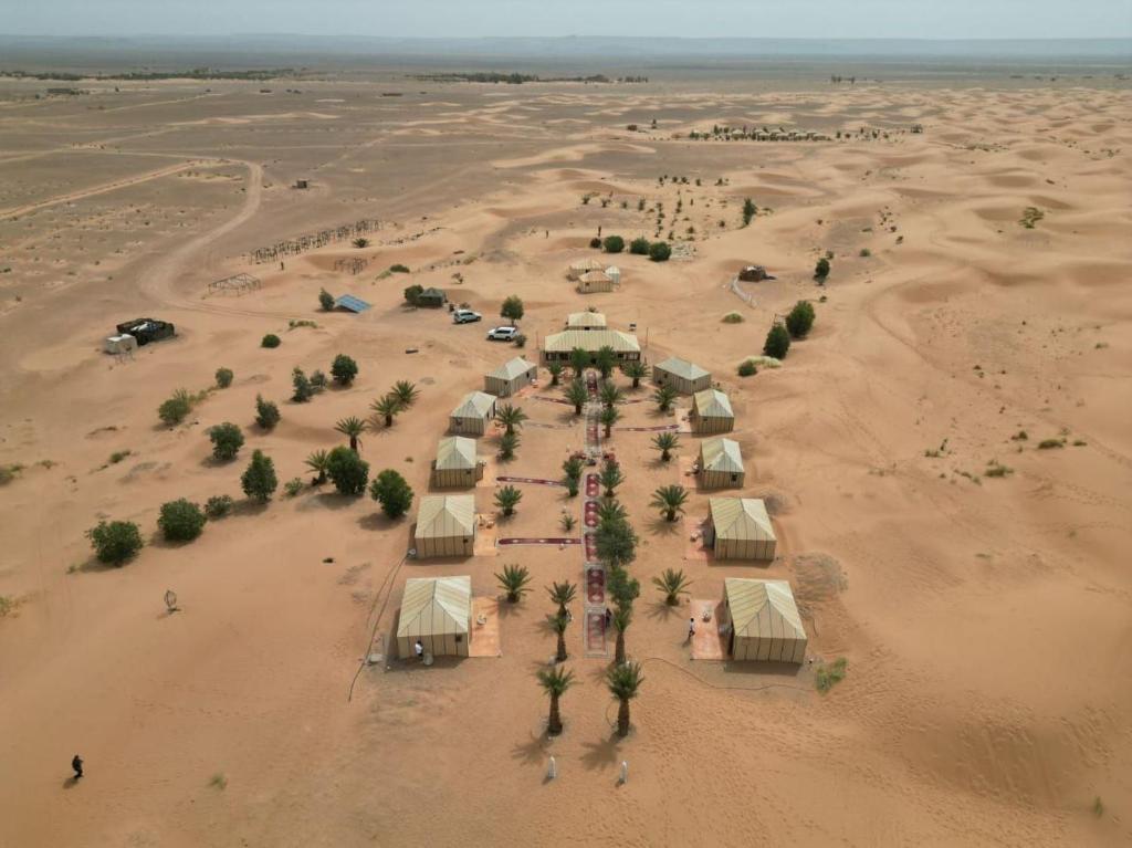 an aerial view of a desert with a group of tents at Sahara Luxury Camp VIP in Merzouga