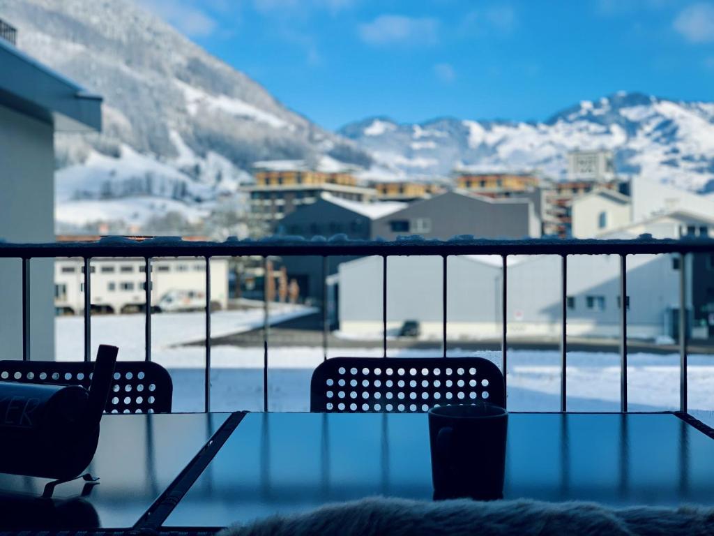 a balcony with two chairs and a view of a mountain at EVA o Wellnessoasis o Montainview o Pizzaoven o in Ingenbohl