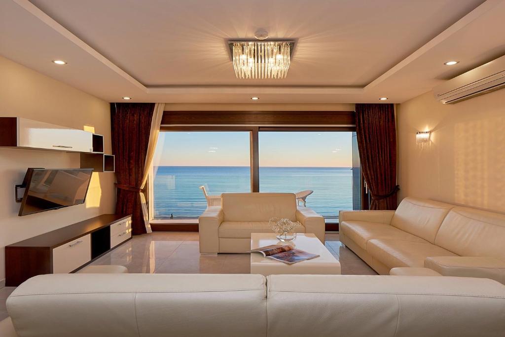 ein Wohnzimmer mit einem Sofa und Meerblick in der Unterkunft Shine Crystal, first line with a stunning view in Čučići