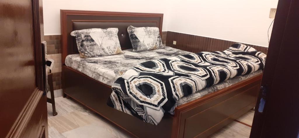een bed met een zwart-wit dekbed en kussens bij HOTEL RIO in Sirhind