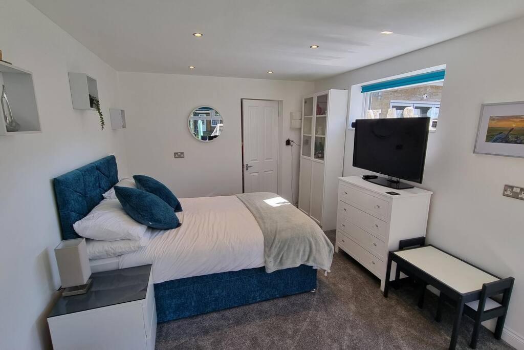 a bedroom with a bed and a television in it at Self-contained annex, with parking. in Kent