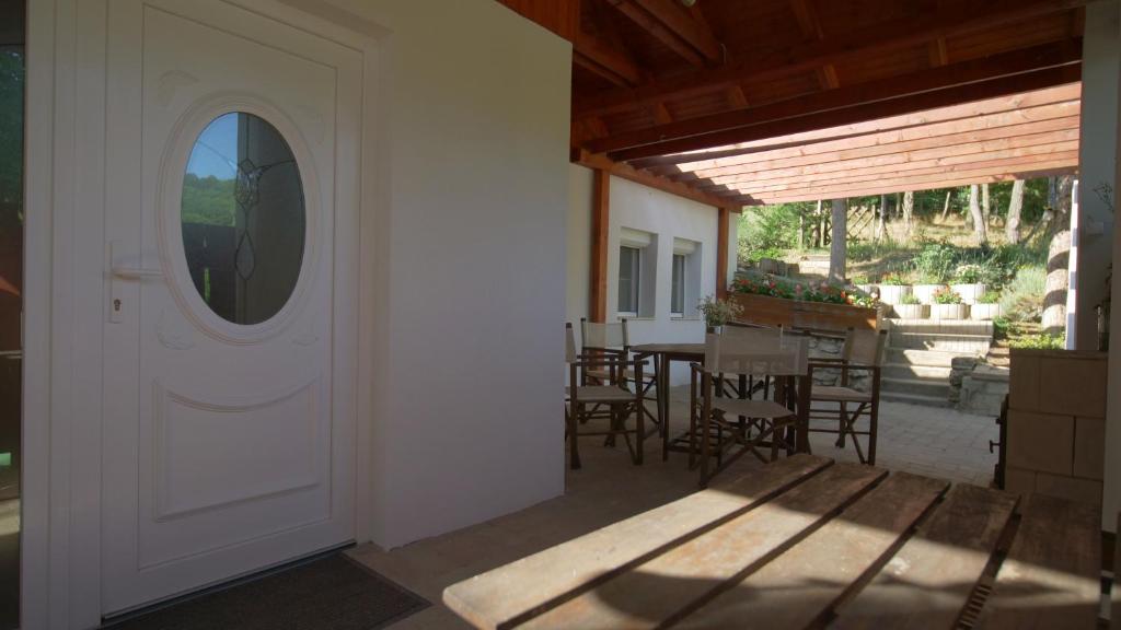 een open deur van een huis met een tafel en stoelen bij Kapolcs Vendégház in Kapolcs