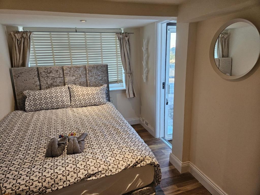 ein Schlafzimmer mit einem Bett mit Schuhen drauf in der Unterkunft Entire en-suite flat in Windsor home with free parking in Windsor