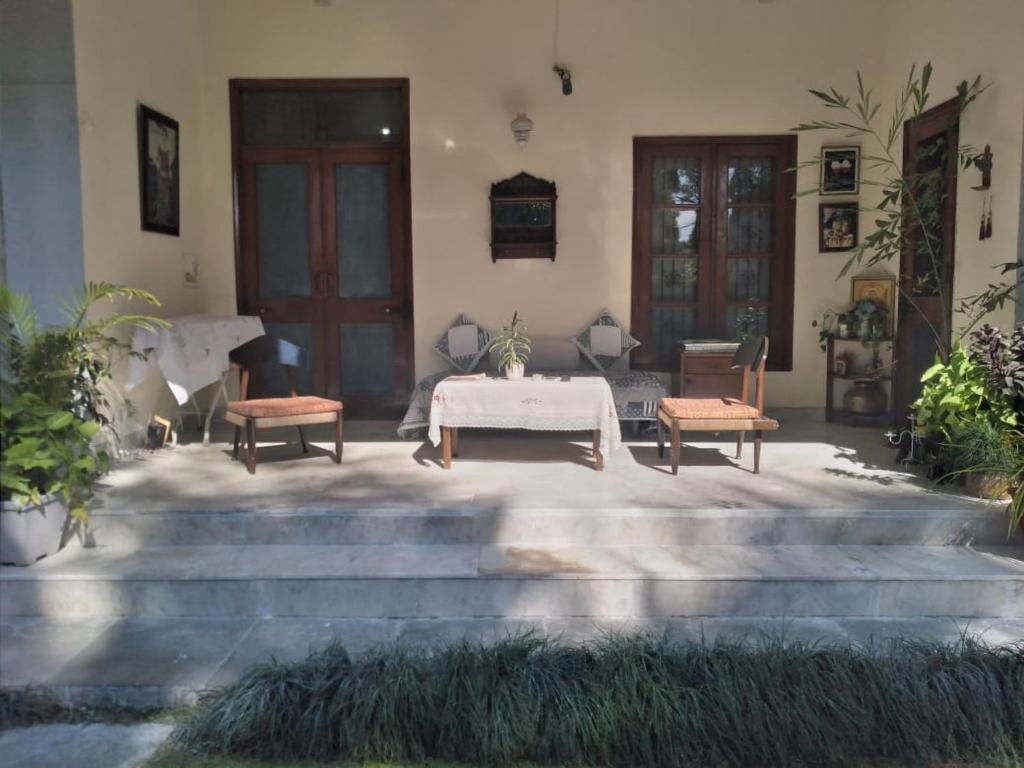 un patio con una mesa y 2 sillas y escaleras en RAJVILAS SUITES en Dehradun