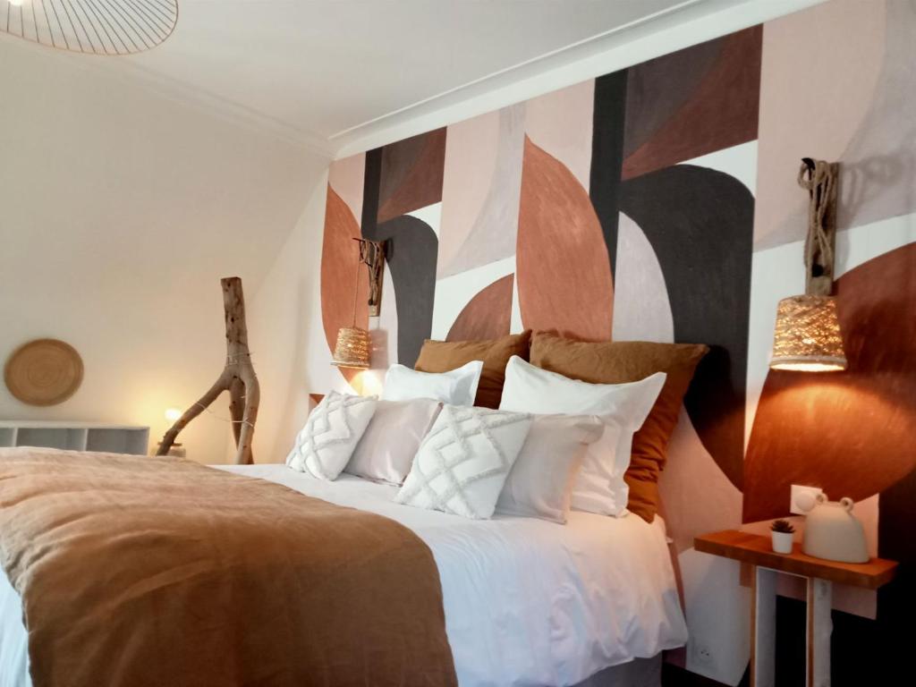 1 dormitorio con 1 cama grande con almohadas blancas en les roches du Cabellou 150M de la mer, en Concarneau