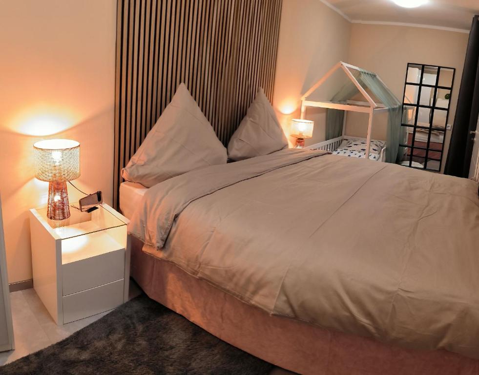 ein Schlafzimmer mit einem großen Bett und einem Nachttisch in der Unterkunft Harz High End Fewo Stefanie Bettwäsche und Handtücher inkl in Goslar