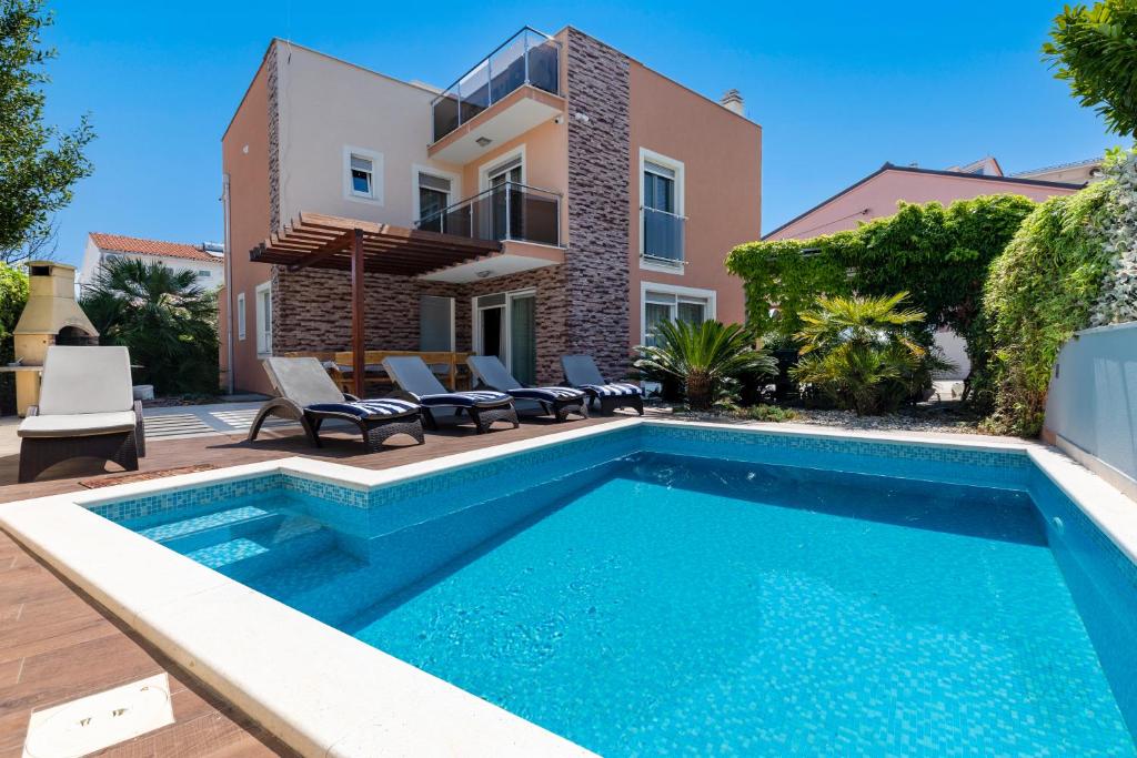 a swimming pool in front of a house at Luxury villa Vincent in Slatine