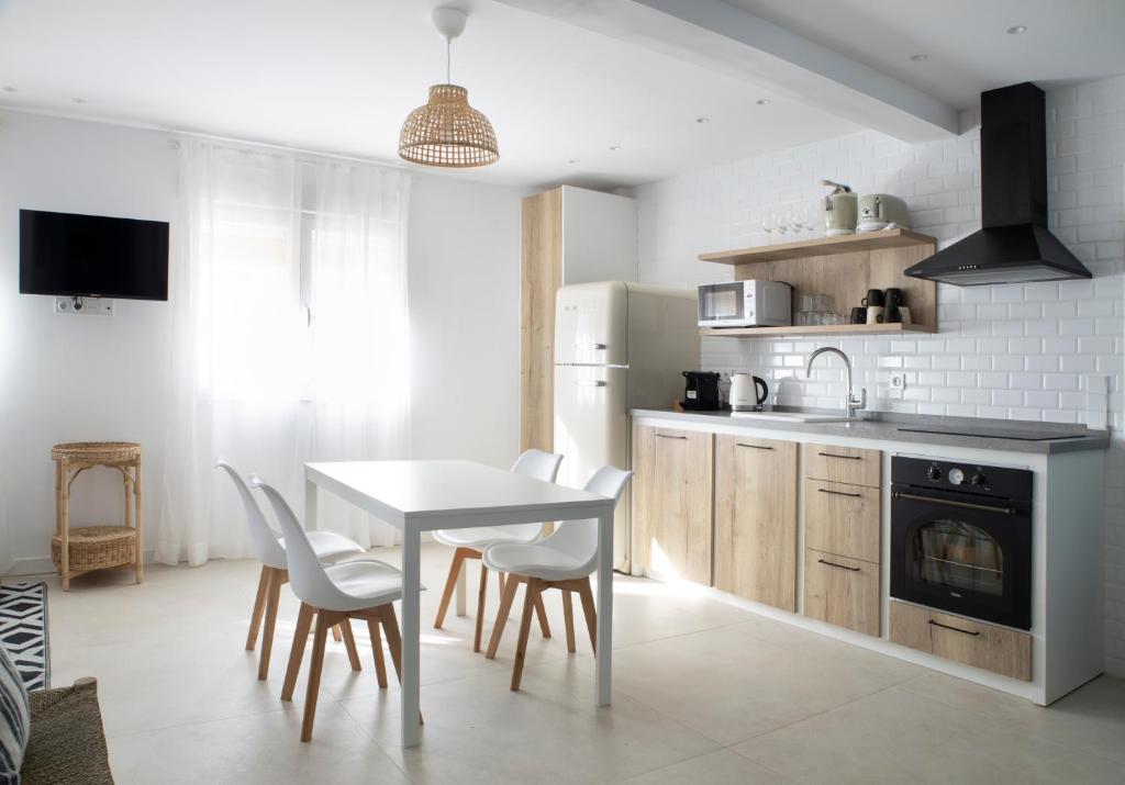 eine Küche mit einem Tisch und Stühlen sowie einem Tisch und einem Herd in der Unterkunft Apartamento Nc Beach Home 31-B in Bellreguart