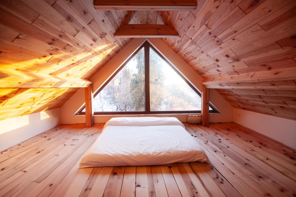 un letto in una camera con una grande finestra di Na Chałupki 