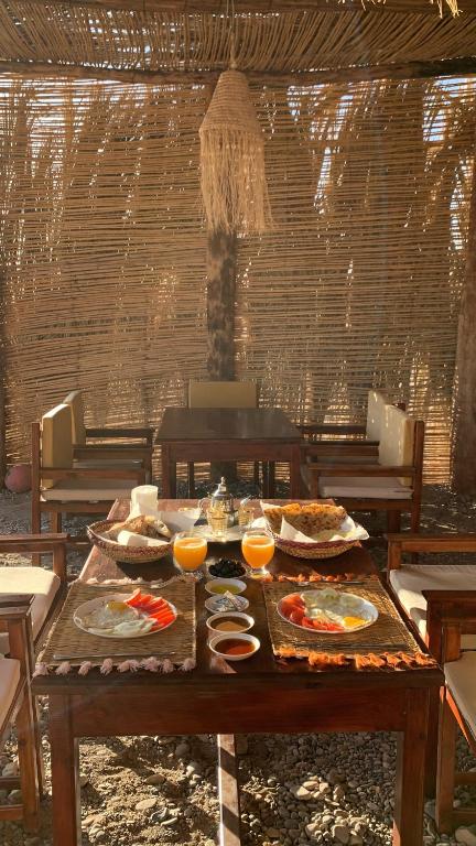 にあるRimal tata campの食べ物と飲み物の盛り合わせが付いたテーブル