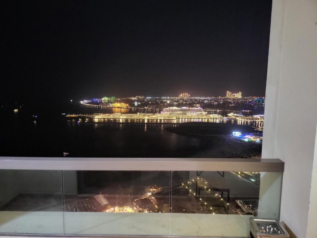 una ventana con vistas a la ciudad por la noche en Atlantis View Hostel en Dubái