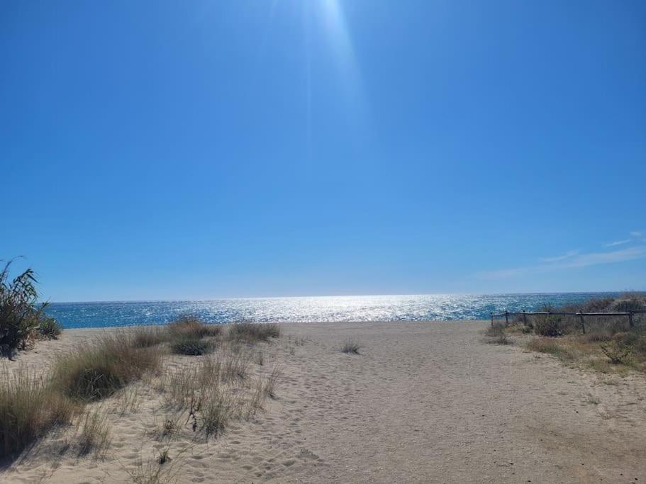 une plage de sable avec l'océan en arrière-plan dans l'établissement Joli studio bleu mer, à Canet