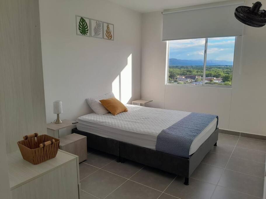 1 dormitorio con cama y ventana grande en Aqualina orange Girardot en Girardot